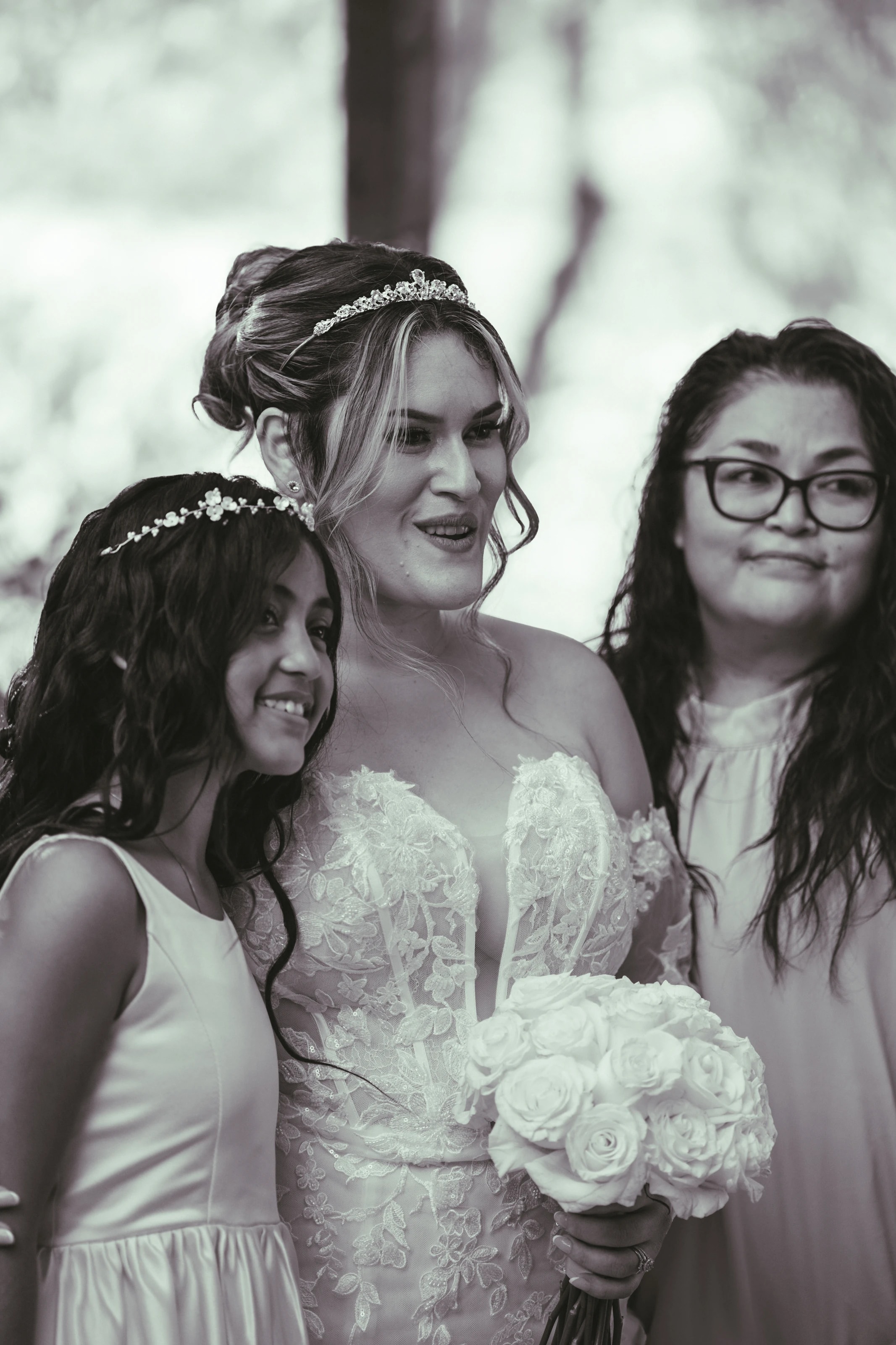 En blanco y negro, la novia ríe junto a dos familiares